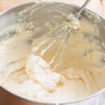 Whipped banana pudding cream cheese frosting in a stainless steel bowl.