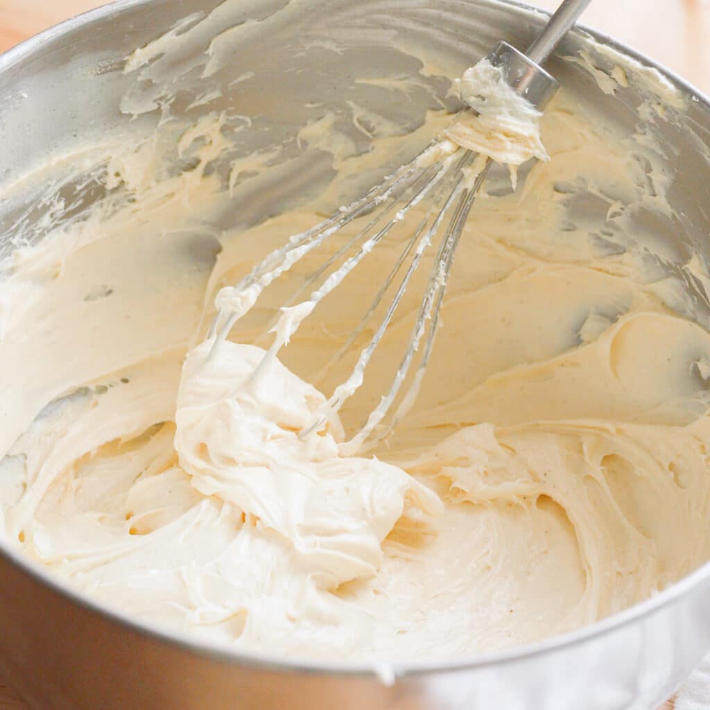 Whipped banana pudding cream cheese frosting in a stainless steel bowl.