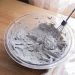 Black sesame cream cheese frosting in a glass mixing bowl.
