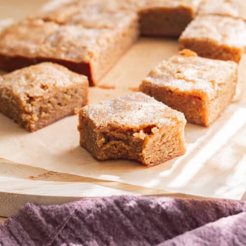 Chai blondie with a bite taken out of it on parchment paper.