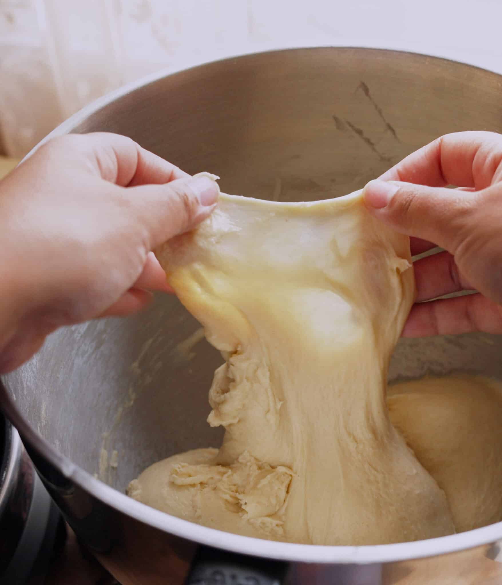Brioche roll dough passing the windowpane test.