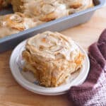 Chai spice cinnamon roll on a white plate.
