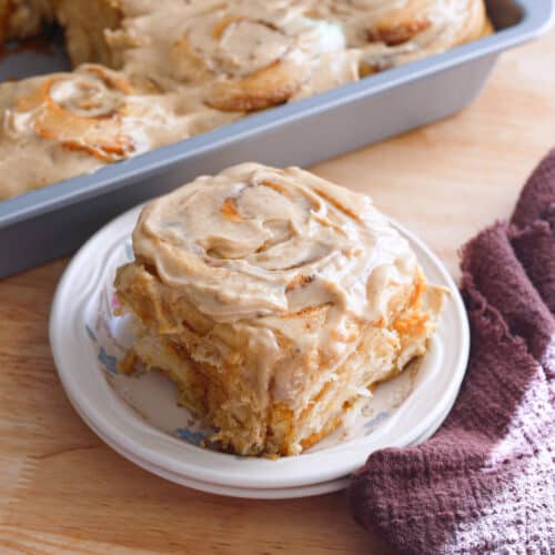 Chai spice cinnamon roll on a white plate.