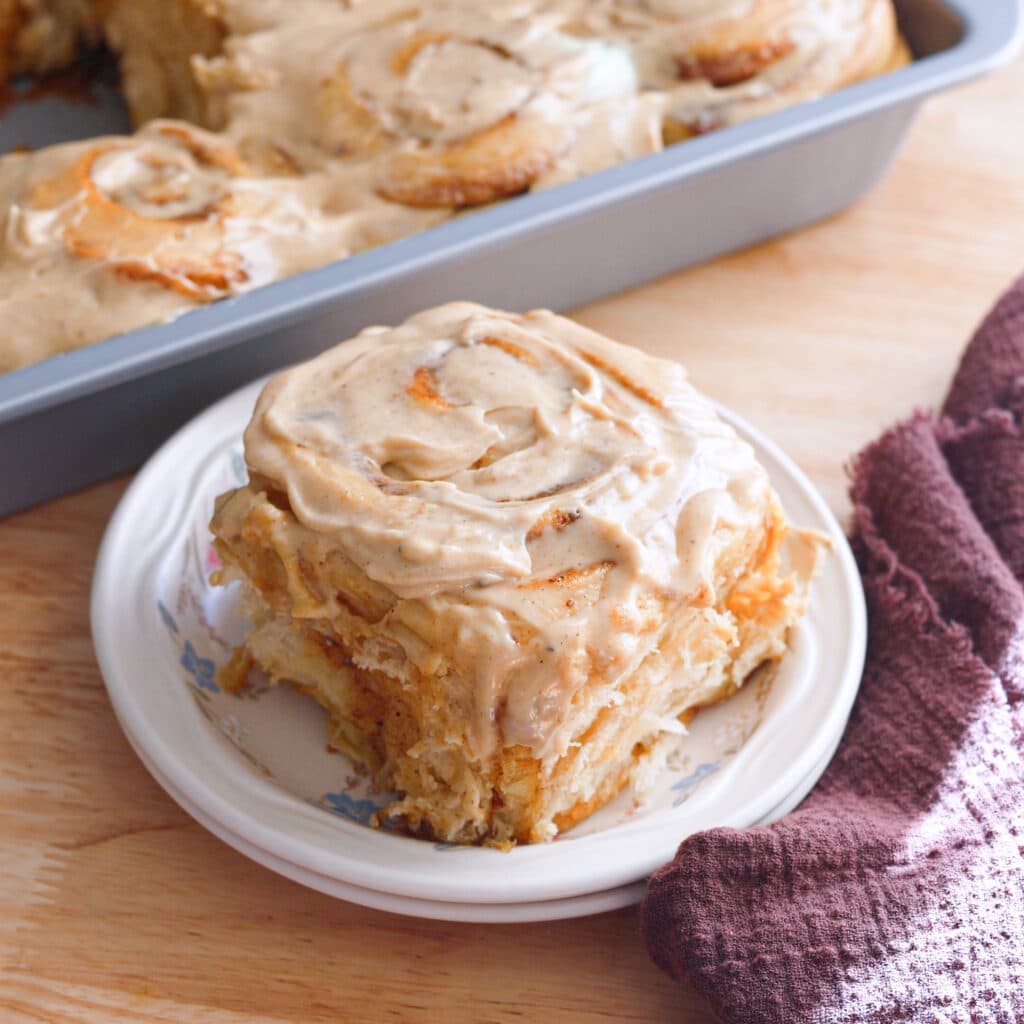 Chai spice cinnamon roll on a white plate.