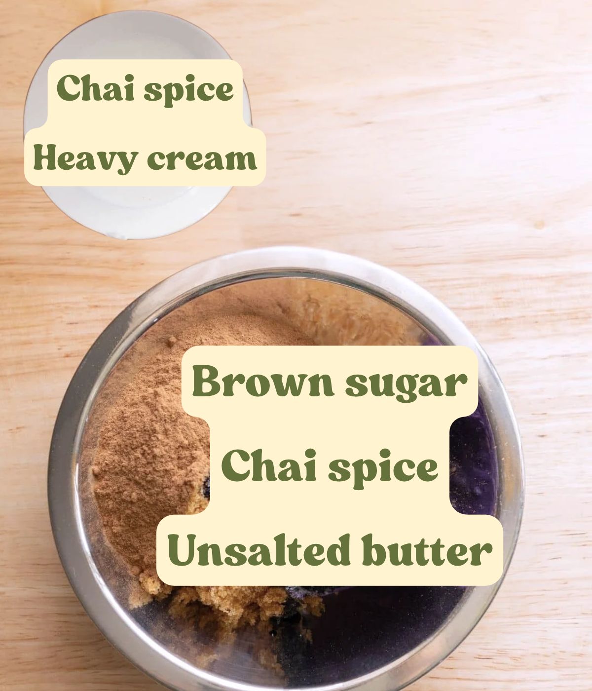 Chai spice cinnamon roll filling and heavy cream mixture ingredients labeled on a wooden table.