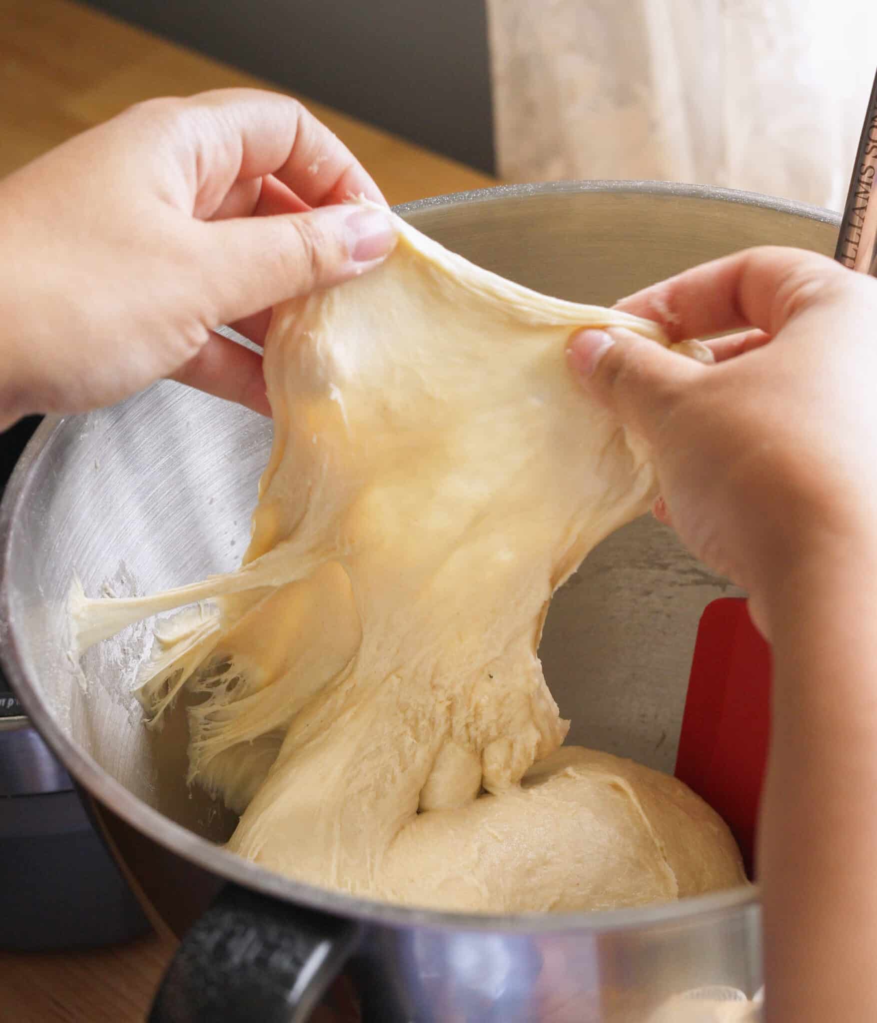 Brioche roll dough passing the windowpane test.