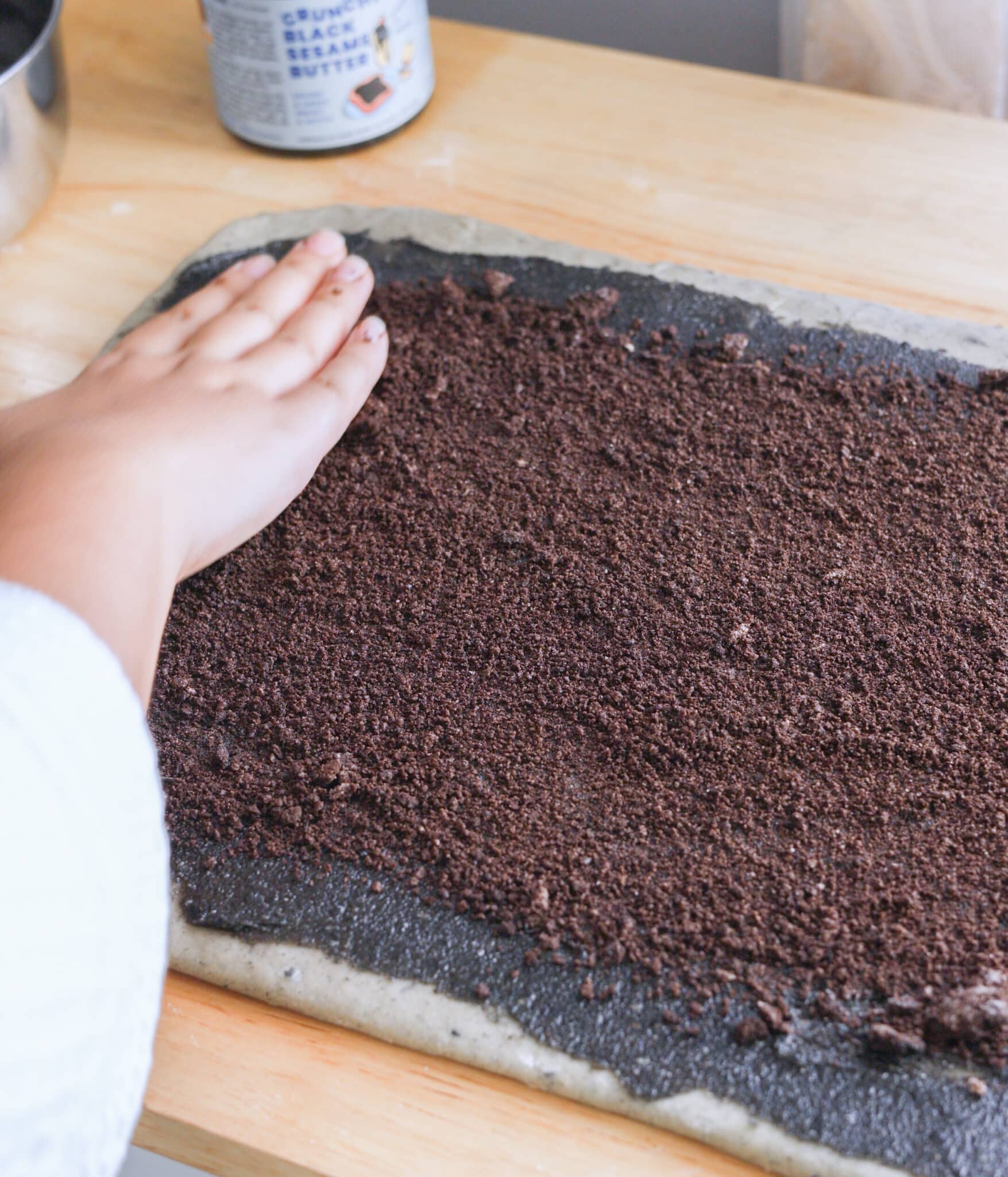 Spreading Oreos in black sesame roll dough.